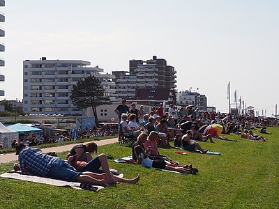 Menschen sitzen auf dem Deich beim Duhner Wattrennen